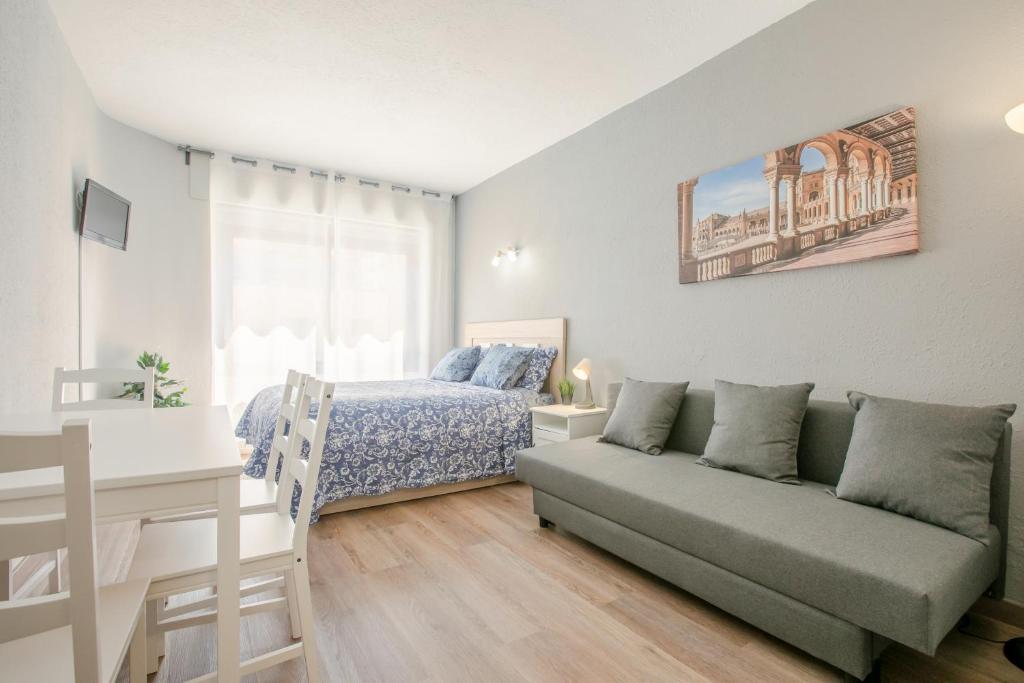 a living room with a couch and a bed at Apartment 233 Hispalis Triana in Seville