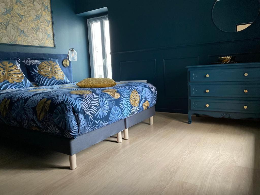 um quarto azul com uma cama e uma cómoda em Appartement cosy en centre ville avec SPA et jardin em Dijon