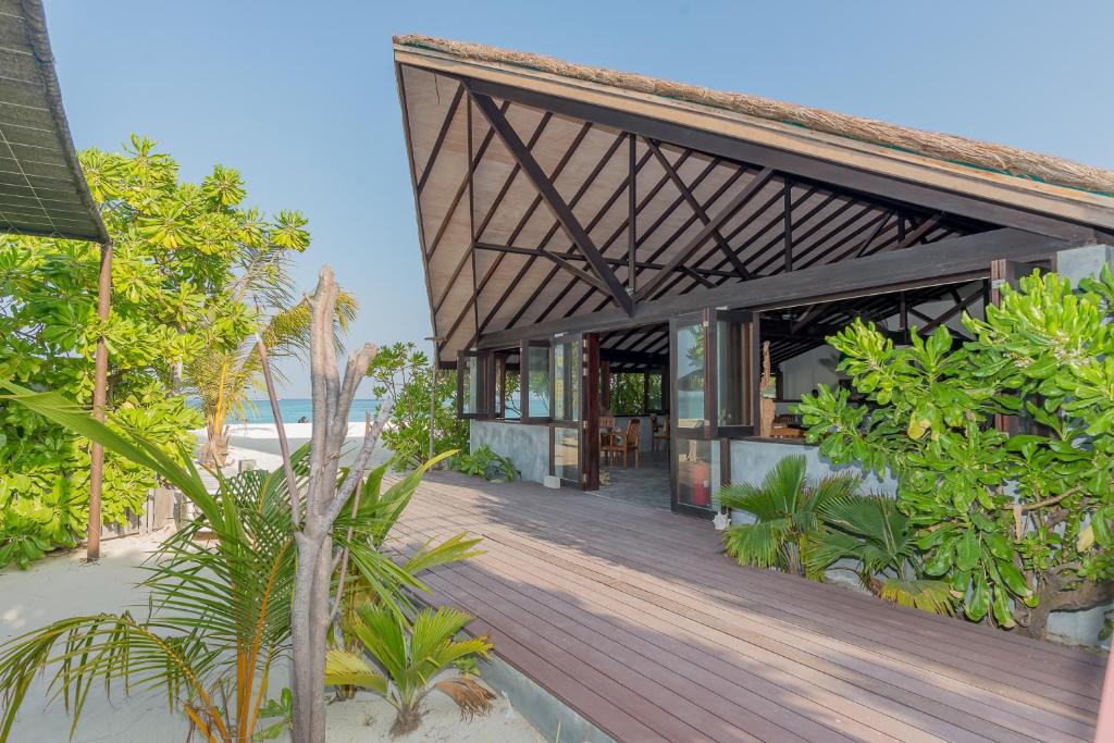 - un bâtiment avec une terrasse en bois à côté de la plage dans l'établissement Premier Beach, à Gulhi