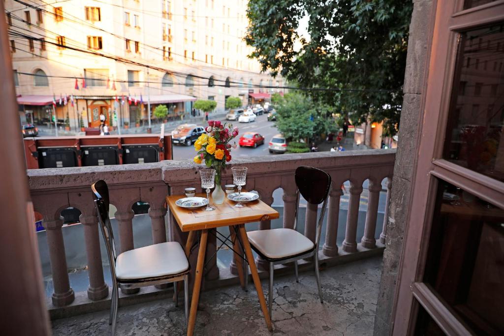 stół z kwiatami i kieliszkami do wina na balkonie w obiekcie Cozy Apartment on Republic Square w Erywaniu