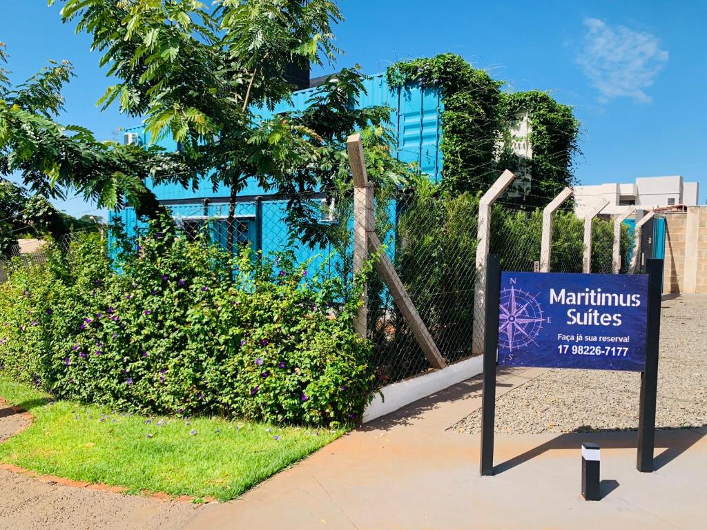 un panneau sur un trottoir devant un bâtiment dans l'établissement Maritimus Suítes, à Barretos