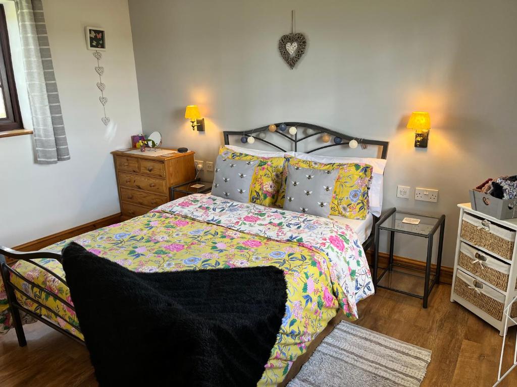 a bedroom with a bed with a colorful comforter at Croft View in Helston