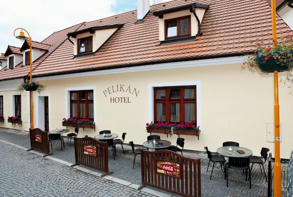 un grupo de mesas y sillas frente a un hotel en Hotel Pelikán, en Třeboň