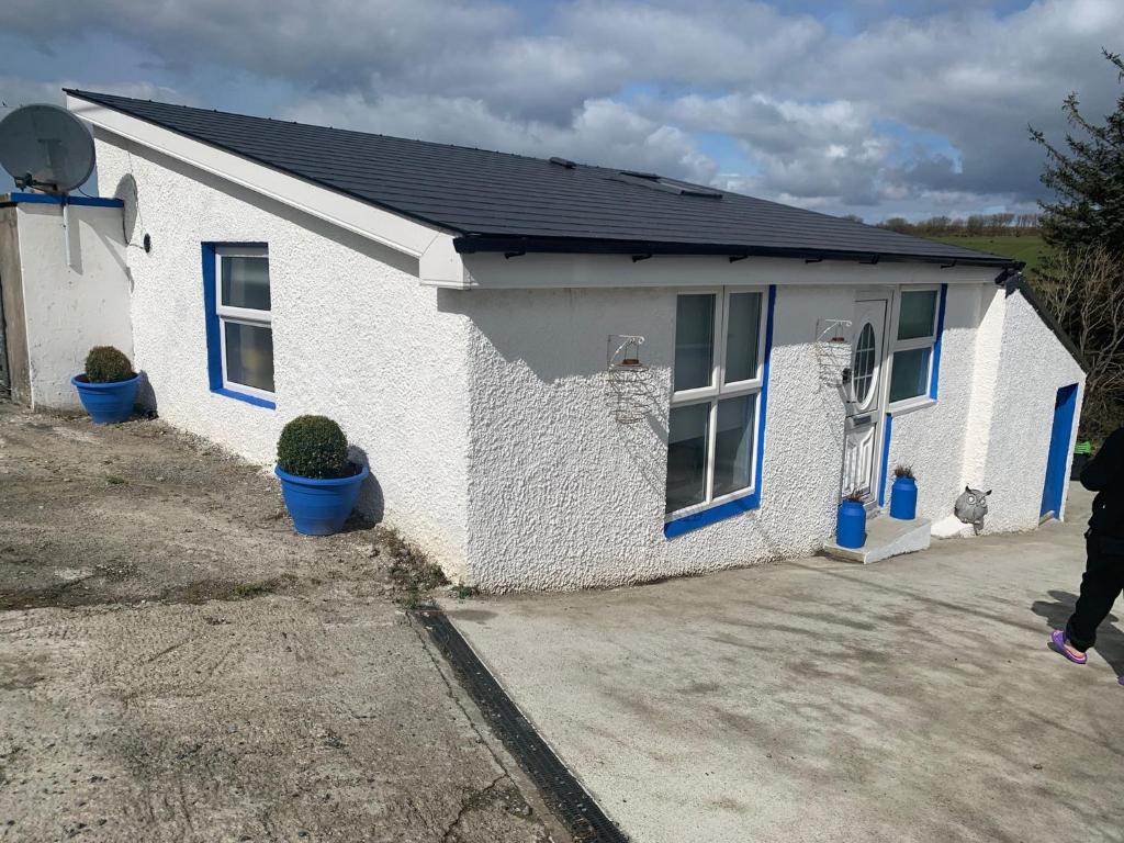 a white house with blue windows and a driveway at The Honeycomb in Ballyshannon