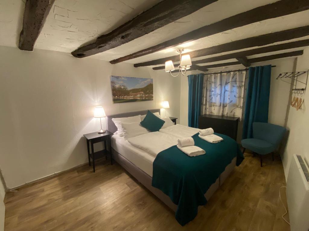 a bedroom with a bed and a blue chair at Mosel Röschen in Bernkastel-Kues