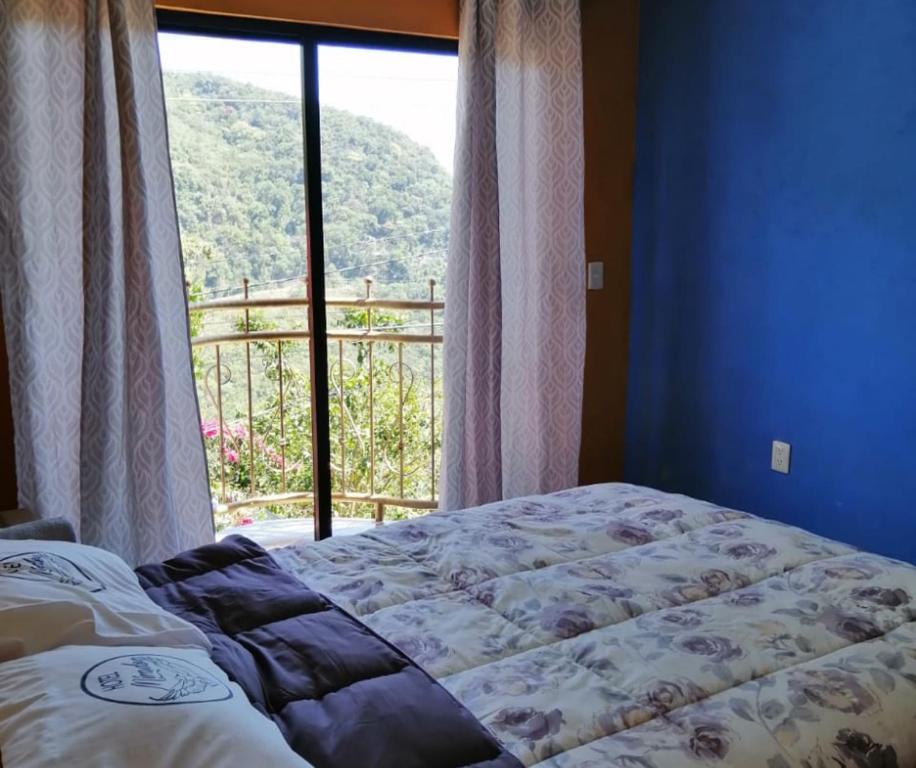 a bedroom with a bed and a window with a view at Hotel El Mirador in Xilitla