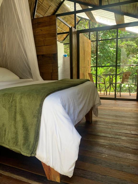 una camera da letto con un letto e una grande finestra di Costeño River Minca a Minca