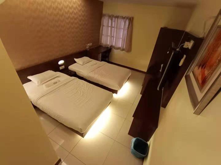 um quarto de hotel com duas camas e uma janela em Home Inn (M4) em Seri Manjung