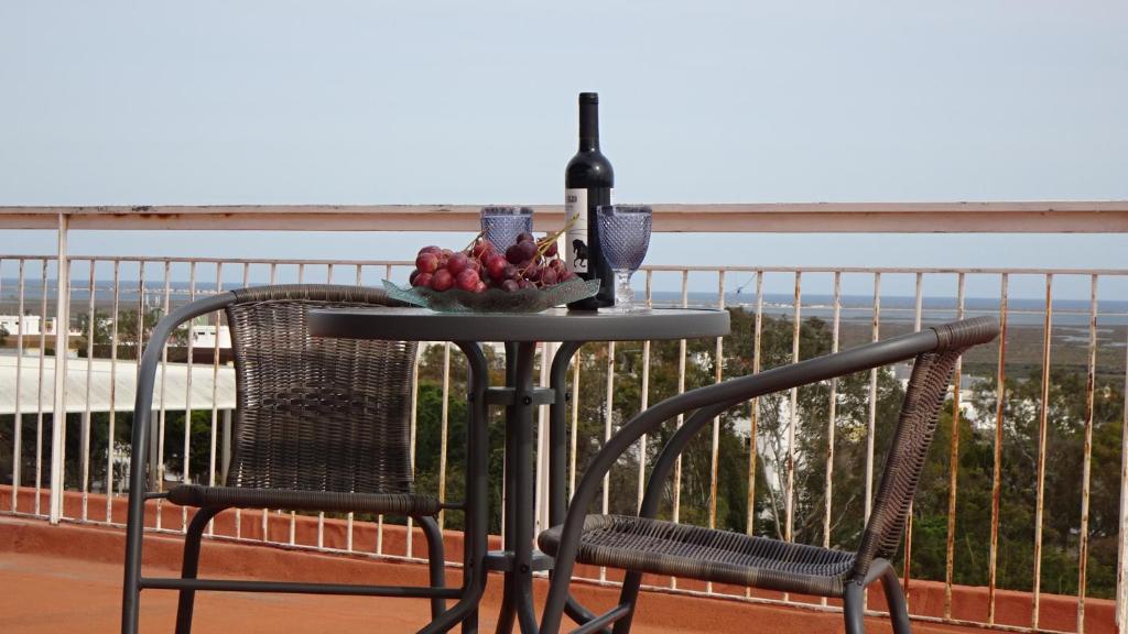 a table with a bottle of wine and a bowl of fruit at BELVEDERE SUITE in Faro