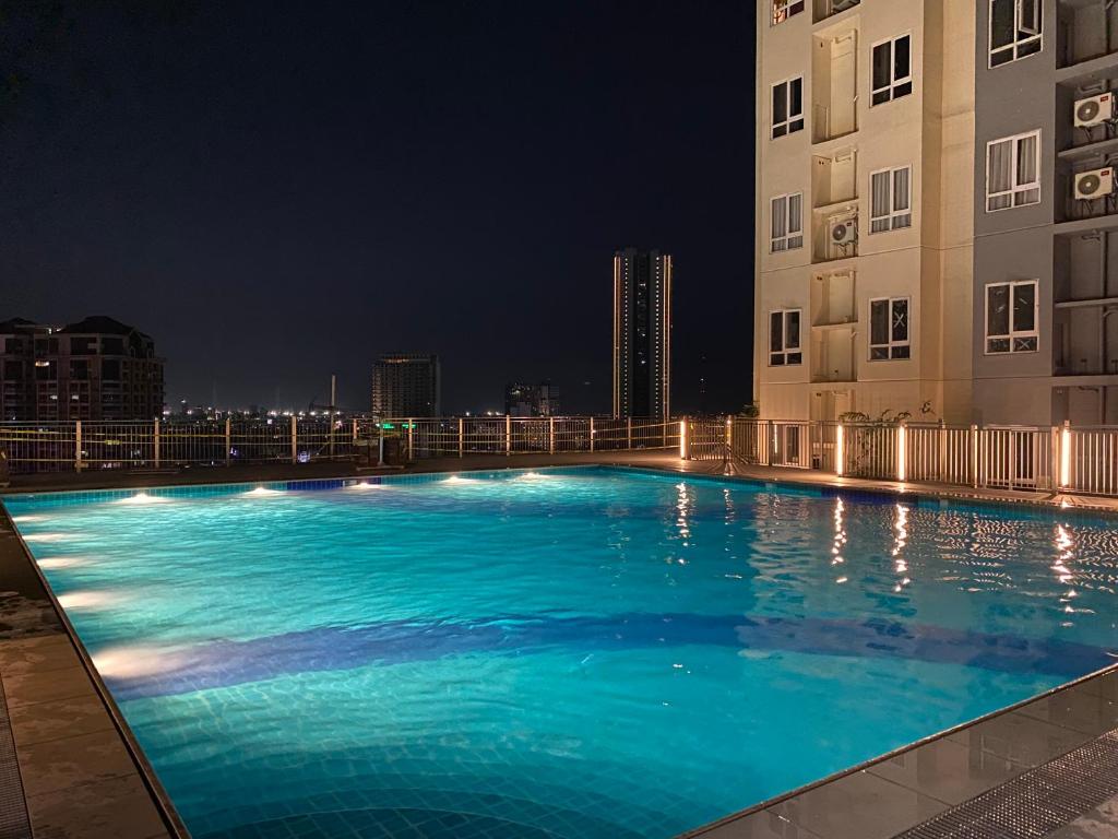 a large swimming pool in front of a building at night at Victoria Sports Tower in Manila
