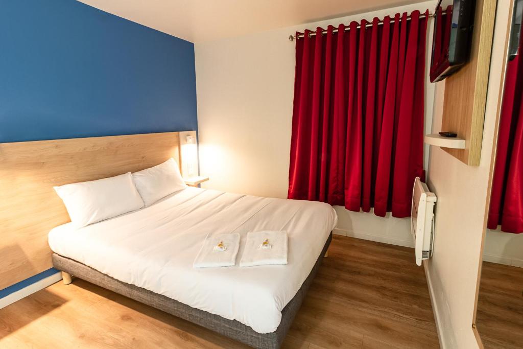 ein Hotelzimmer mit einem Bett und roten Vorhängen in der Unterkunft BRIT Hotel Rouen Nord - Barentin in Barentin