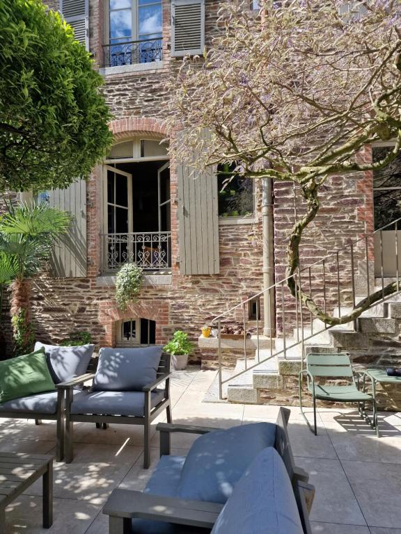 un bâtiment en briques avec des tables et des chaises devant lui dans l'établissement Castel Jolly, à Rennes