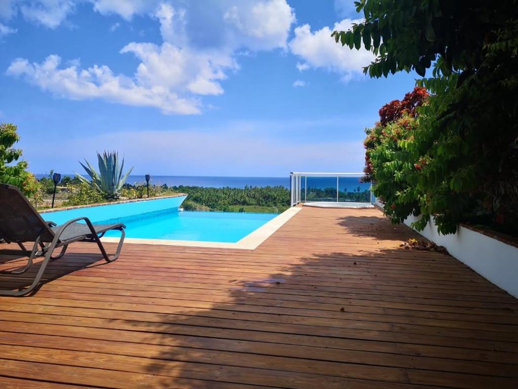 a wooden deck with a bench next to a swimming pool at Piece of Paradise in Las Terrenas