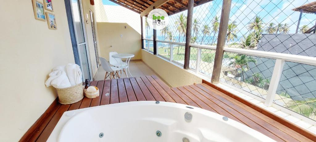 a bath tub in a room with a balcony at COSTE0100 - Residencial Luz das Acácias in Salvador