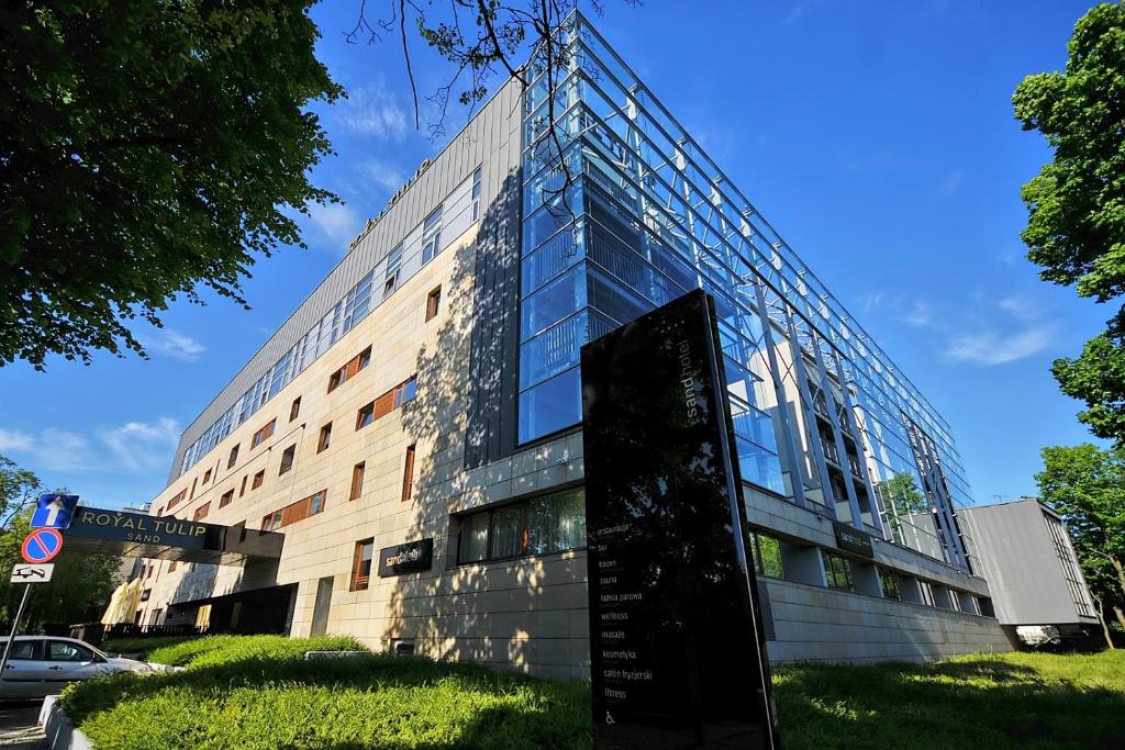 ein Glasgebäude mit einem Schild davor in der Unterkunft 313 w PIĘCIOGWIAZDKOWYM HOTELU ROYAL TULIP SAND plaża 200 m DOBRUK APARTAMENTY in Kołobrzeg