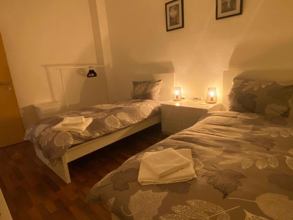 two beds in a small room with two candles at Zum guten Schlaf in Bremen