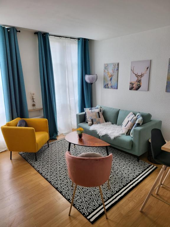 sala de estar con sofá verde y 2 sillas en Appartement centre ville chic et cozy, en Vendôme