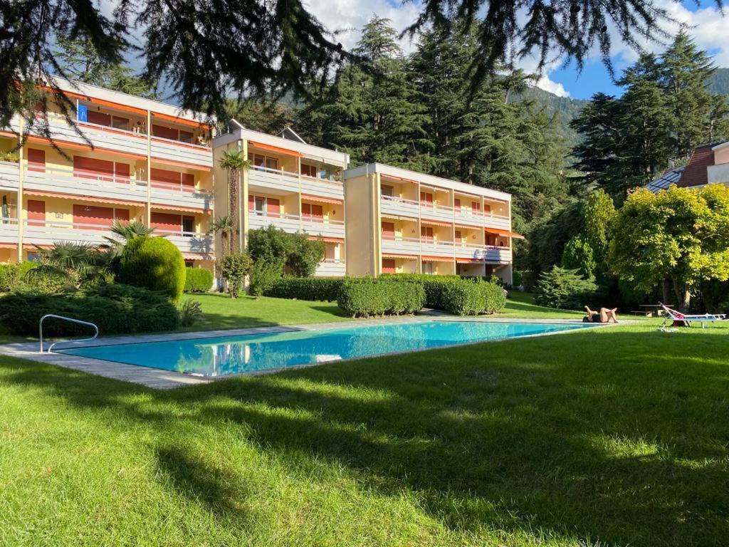 a swimming pool in front of a building at Garden Pool Apartment in Merano
