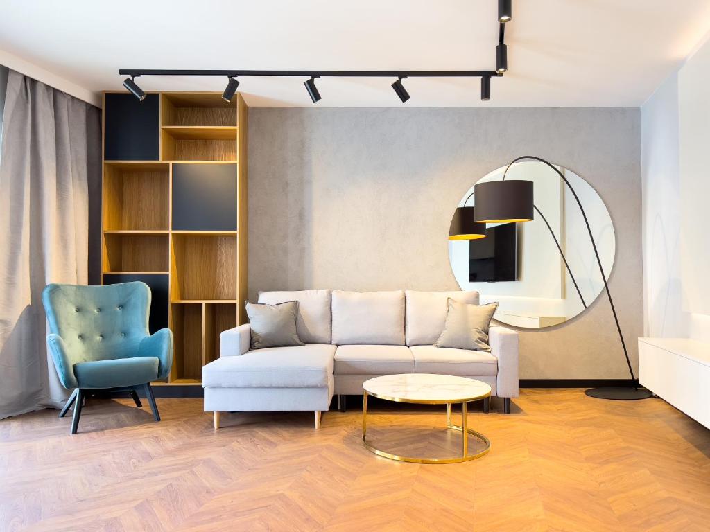 sala de estar con sofá y espejo redondo en Mint Apartments Premium Gdynia, en Gdynia