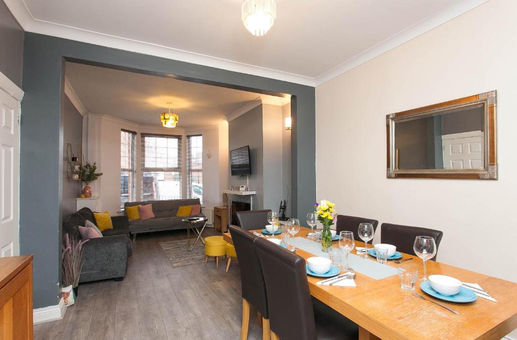 a dining room and living room with a table and chairs at Titanic The Lady, 3 Bed Townhouse in Belfast