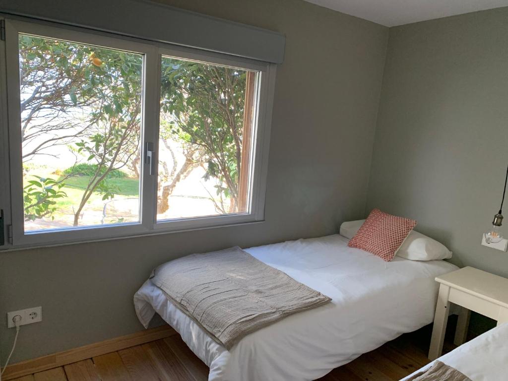 a bed in a room with a large window at Calle do Reiro, Casa o chalet in Nigrán