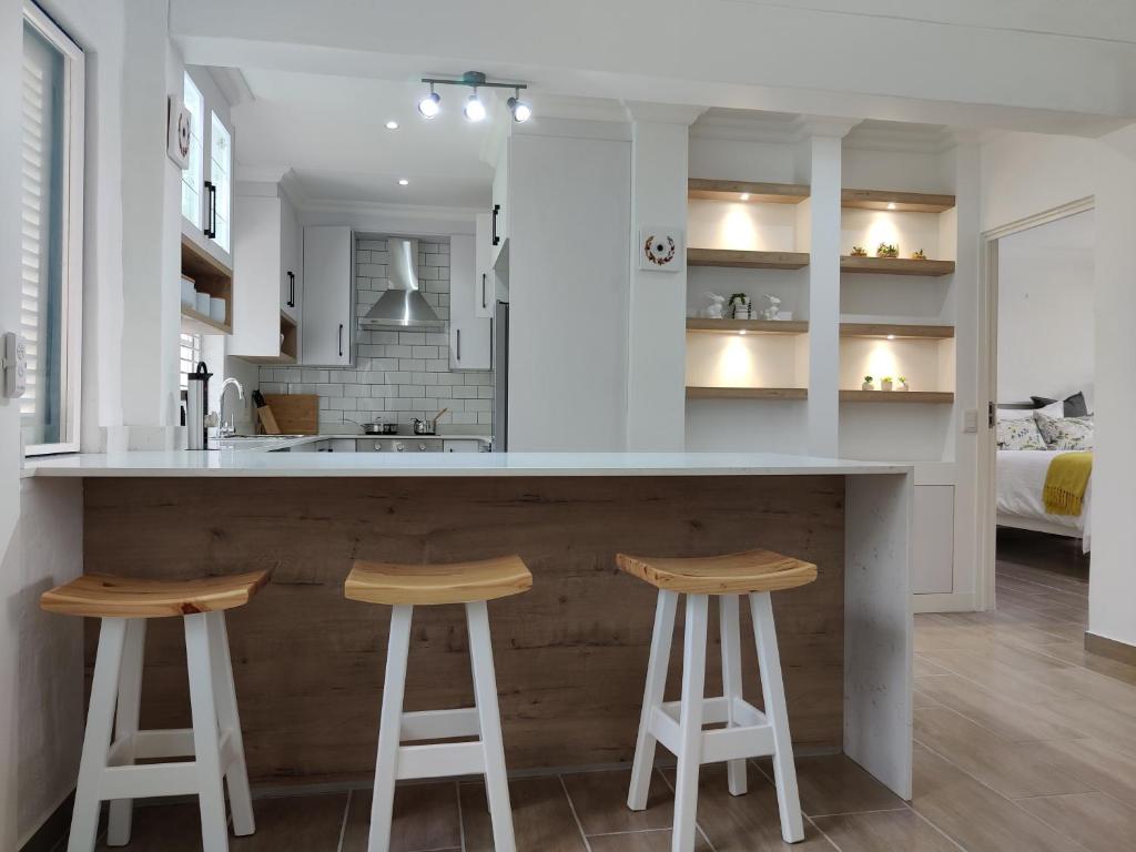 a kitchen with two bar stools and a kitchen with a bed at 44 Montego Bay Caribbean Estates in Port Edward