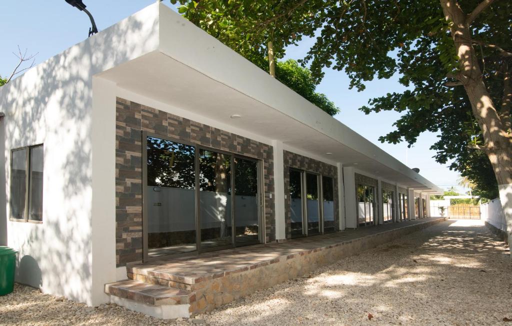 ein weißes Gebäude mit Fenstern und einem Baum in der Unterkunft Hotel Zabdi in Coveñas