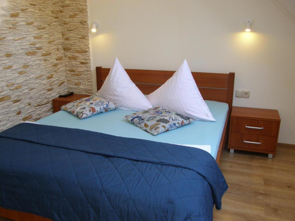 a bedroom with a blue bed with two pillows at Apartament Fregata in Kołobrzeg