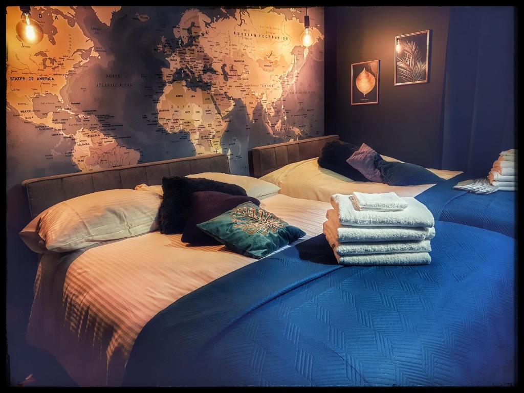 2 Betten in einem Zimmer mit einer Karte an der Wand in der Unterkunft Sasaki Sauna i Bania in Szczutków