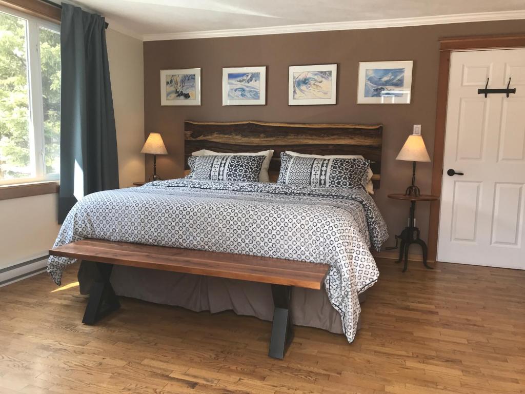 1 dormitorio con 1 cama grande y suelo de madera en Canadian Rockies Inn - Adults only, en Field