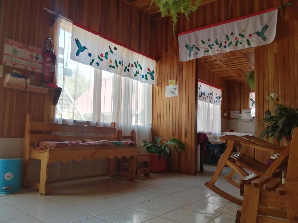Cette chambre dispose d'un lit et d'une fenêtre avec des oiseaux sur les murs. dans l'établissement Pensión y Cabinas Colibrí B&B Costa Rica, à Monteverde Costa Rica