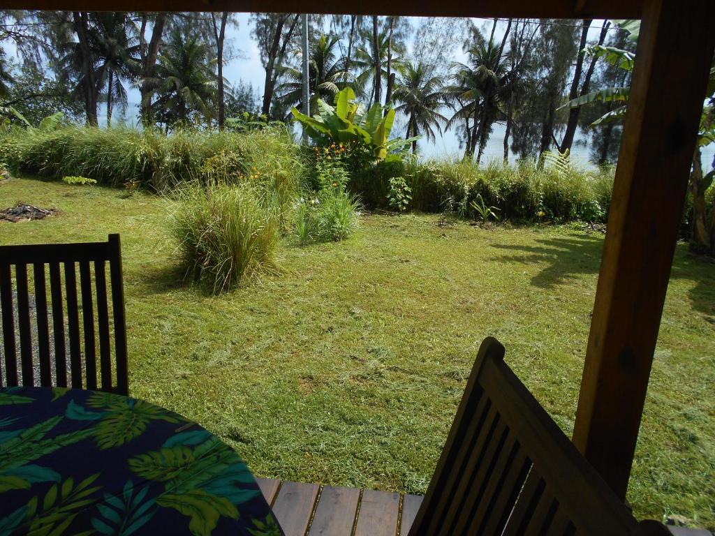 a porch with a table and chairs and a yard at Fare Hanuatai in Tevaitoa