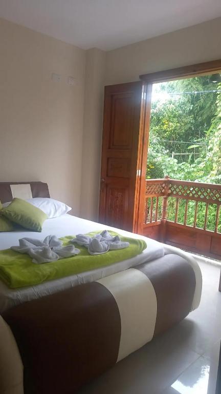 a bedroom with a bed and a window with a balcony at Mi Balconcito in Salento