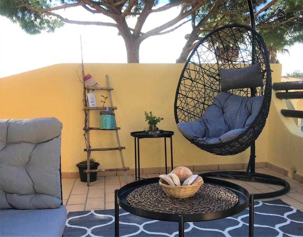 - un salon avec une balancelle et une table dans l'établissement Ela's Terrace, à Alvor