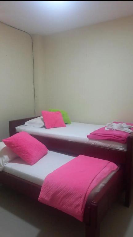 two beds in a room with pink towels on them at Mi Balconcito in Salento