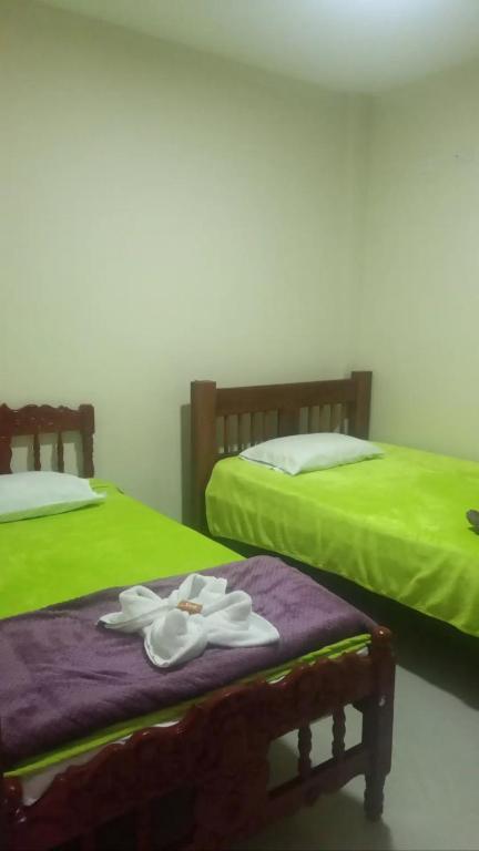 two beds with flip flops and towels on the bed at Mi Balconcito in Salento