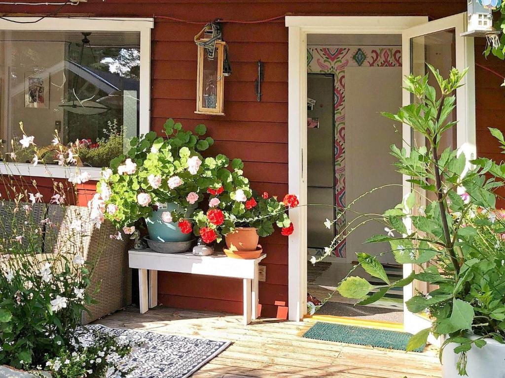- une terrasse couverte avec des fleurs sur une table à côté d'une porte dans l'établissement Holiday home ORNÖ, à Ornö