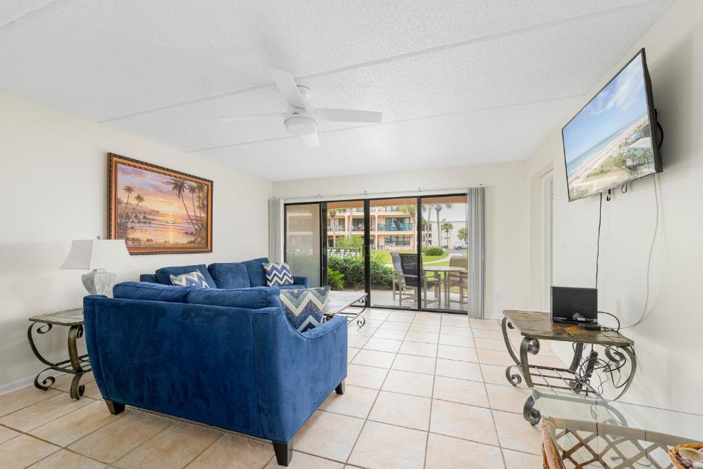 a living room with a blue couch and a tv at Sea Place 14164, 3 Bedrooms, Sleeps 8, Ground Floor, Pool, Tennis, WiFi in St. Augustine