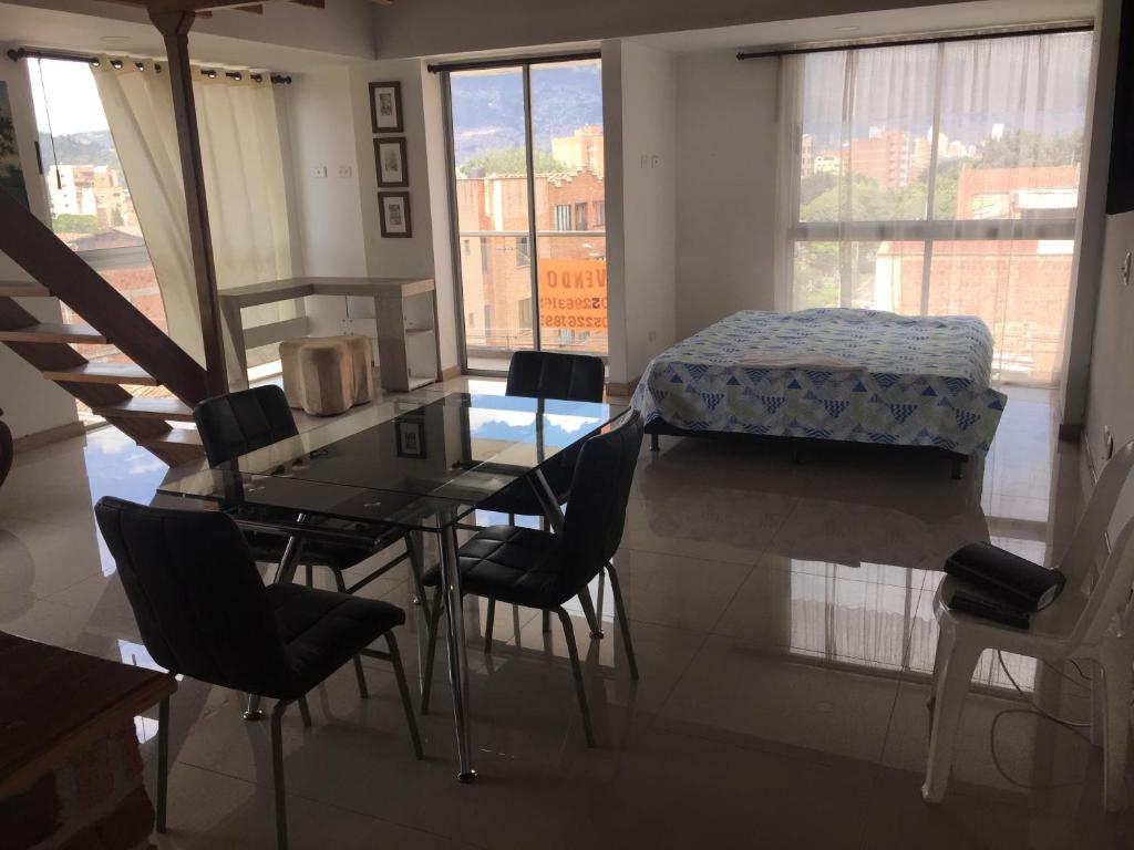 Zimmer mit einem Tisch, Stühlen und einem Bett in der Unterkunft Apartamento Lof , Dúplex , iluminado ,bueno , céntrico y bien ubicado in Medellín
