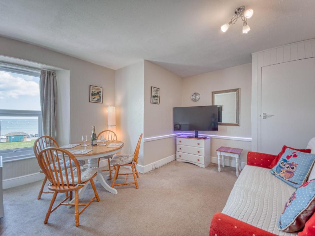 a living room with a table and a tv at Apartment 5 - 1 Bedroom Sea Front-Sea Views-Free Parking in Paignton