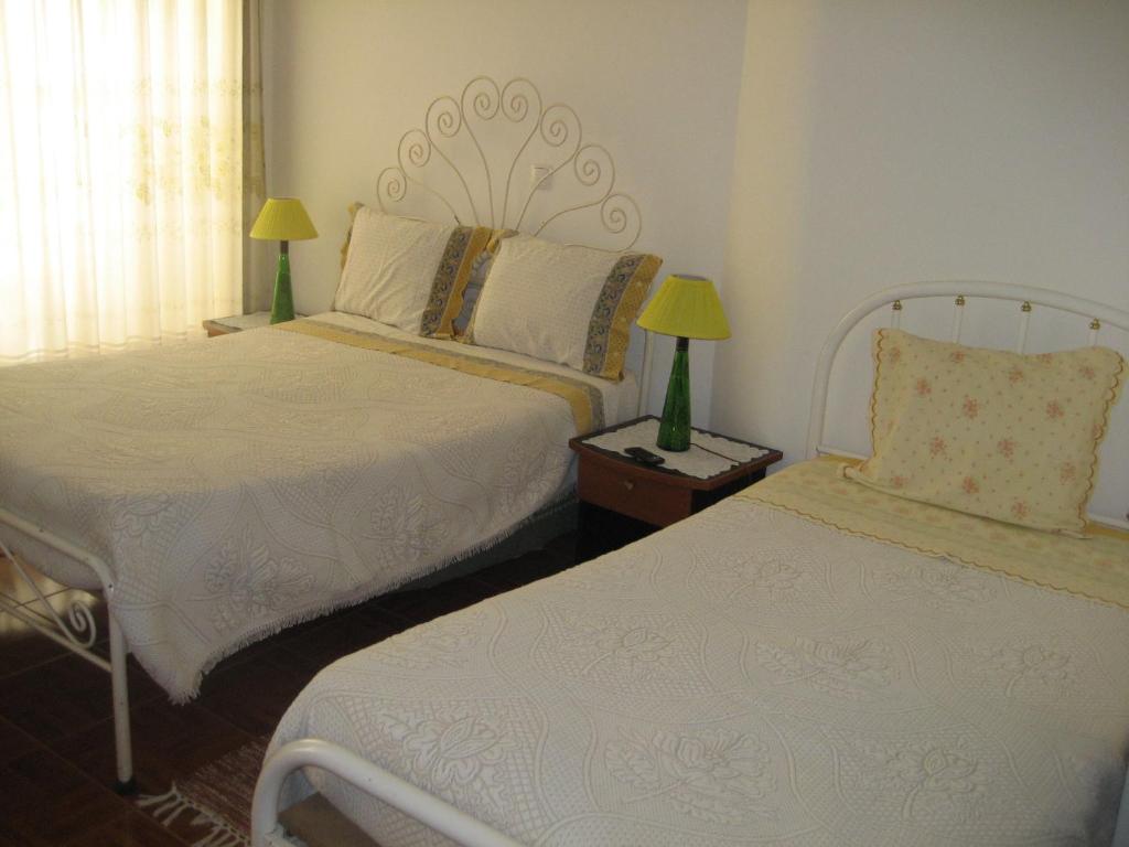 a bedroom with two beds and two lamps on a table at Residencia do Norte in Lisbon