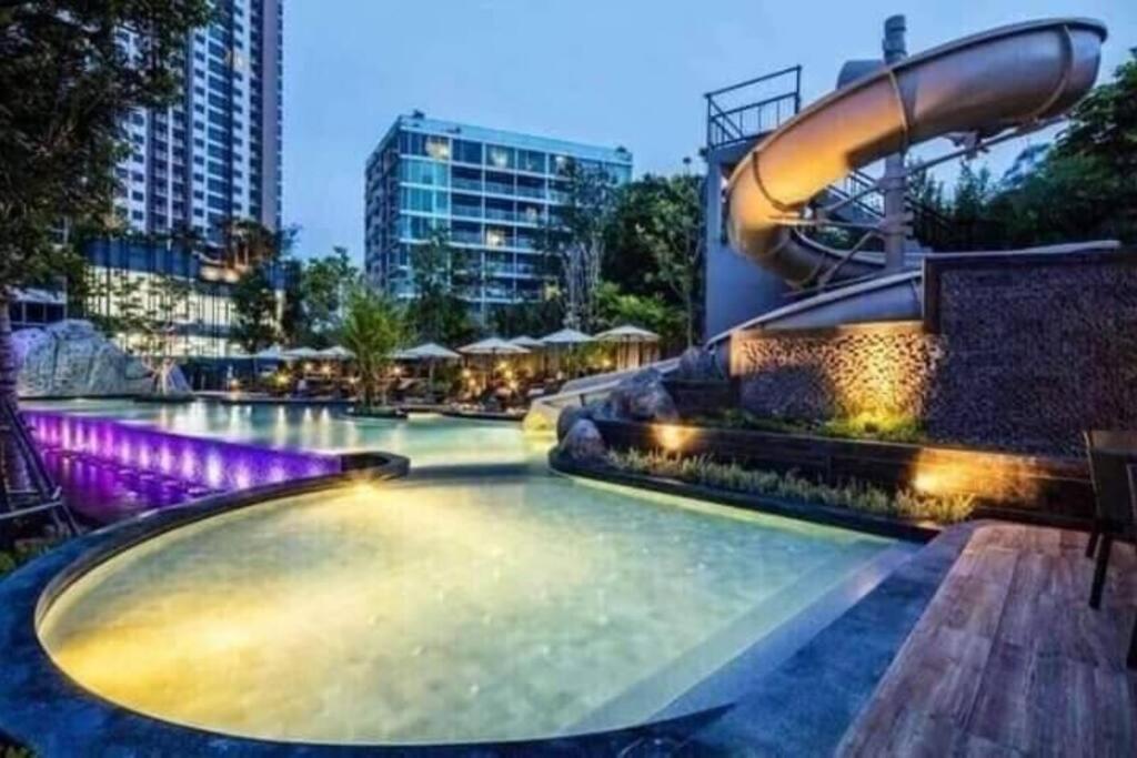 a large swimming pool with a water slide at unixx condo pattaya near walking street in Pattaya South