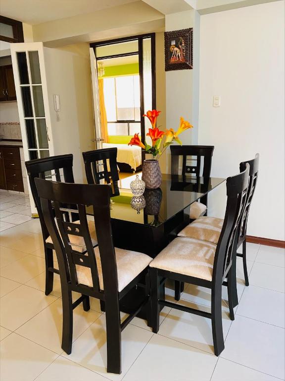 a dining room with a black table and chairs at Departamento Los Manantiales Cusco in Cusco