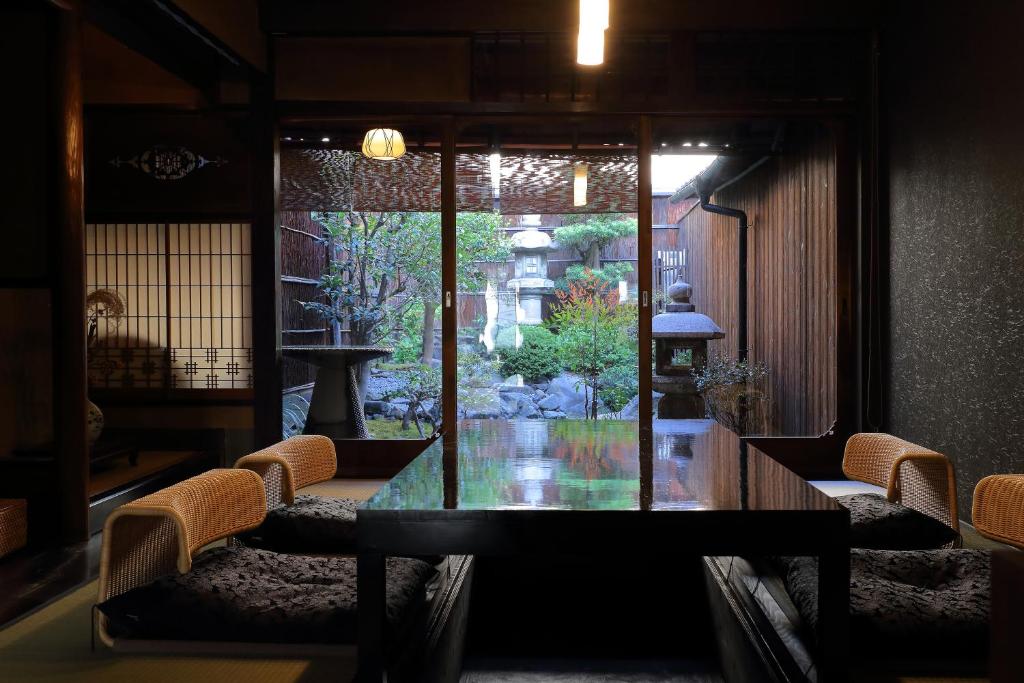 a dining room with a glass table and chairs at Kyo no oozora FUKA in Kyoto