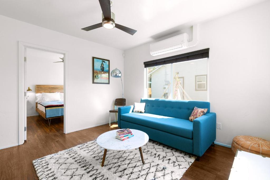 een woonkamer met een blauwe bank en een tafel bij Saint Boniface Hotel in Indio