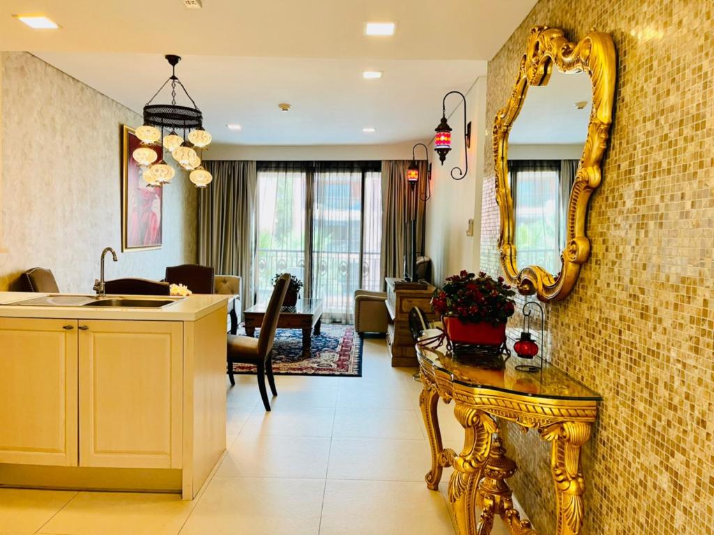 Sala de estar con espejo de oro y mesa en Baan Marakesh Hua Hin en Hua Hin