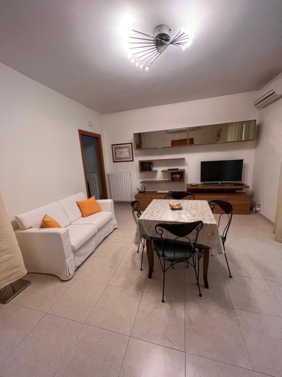 a living room with a white couch and a table at Appartamento Modugno centro (Bari) in Modugno