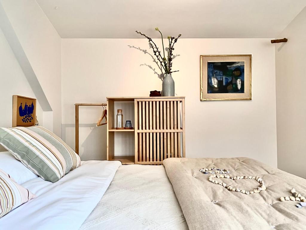 a bedroom with a white bed with a necklace on it at Romantic Wellness BnB Noordwijk in Noordwijk aan Zee