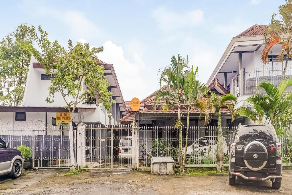 a car parked in front of a house at SPOT ON 90797 Sukun Syariah Homestay in Malang
