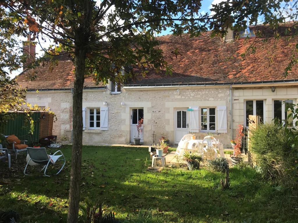 a white brick house with a yard with chairs at Bblodges Loches Beauval in Saint-Hippolyte